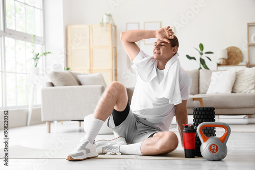 Tired sporty young man with...