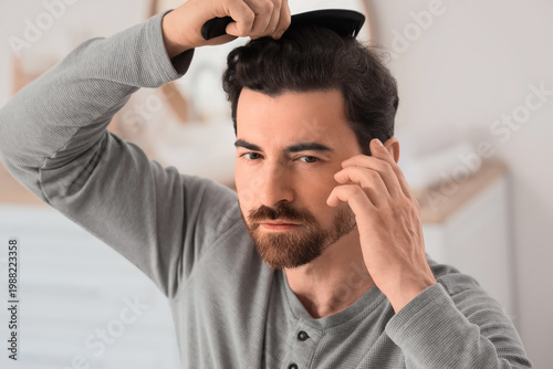 Man combing hair at home