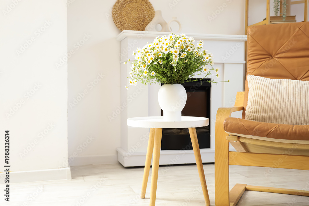 Obraz premium Vase with chamomiles on table in living room