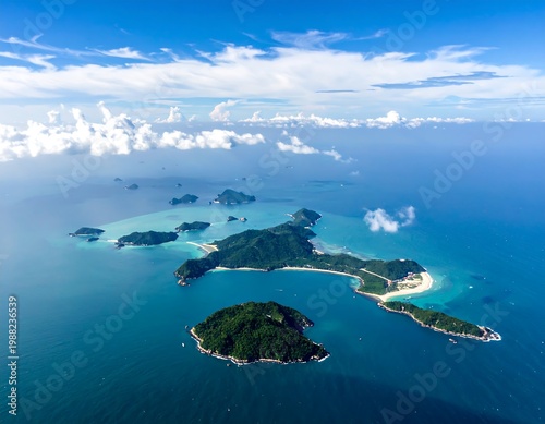 Aerial view captures numerous tropical islands under a bright blue sky, surrounded by turquoise waters and wispy clouds