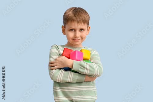 Little boy with autistic disorder and cubes on blue background