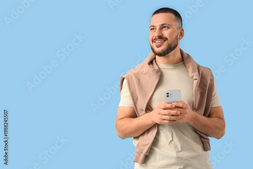 Happy young man with mobile...