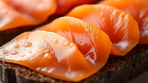 tonalite. Close-up of oily smoked salmon slices on dark rye bread. menu design, packaging mockups, designed for culinary blogs and recipe cards for restaurants, used by interior designers.