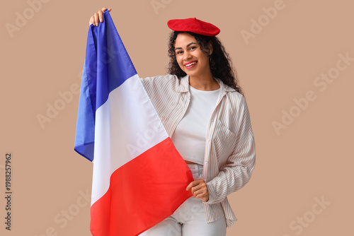 Beautiful young happy African-American woman in beret with flag of France on ...