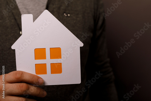 Hand holding house cutout, ...