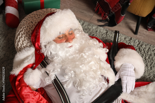 Drunk Santa Claus with bottle sleeping on carpet after party, top view