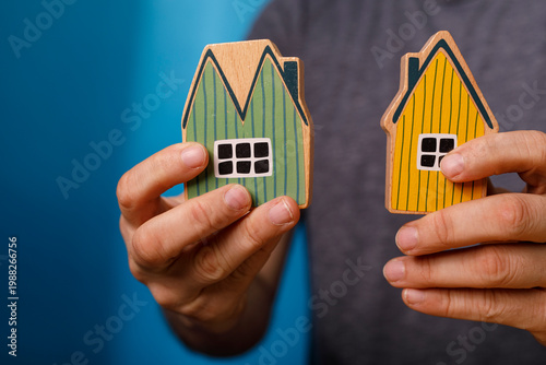 Person holding toy houses s...