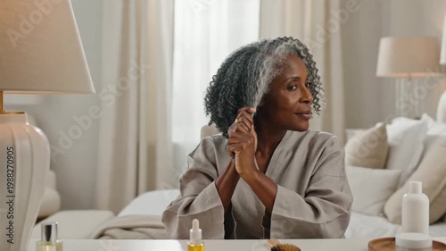 Elegant Mature Woman with Beautiful Silver Hair Gently Brushing and Caring for Her Textured Locks