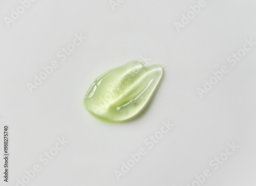 Green cosmetic texture with bubbles isolated on light background, close-up. Skincare smear aloe vera, natural and organic ingredients