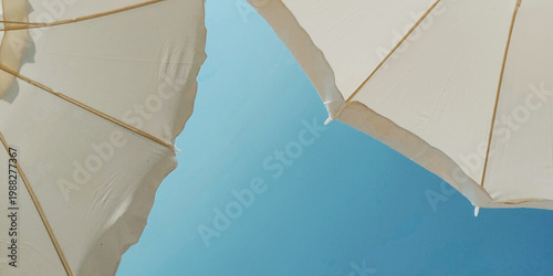 Sky-High Serenity: A unique perspective on sun umbrellas against a vibrant, cloudless azure sky, offering a sense of openness, tranquility, and the promise of a perfect day.