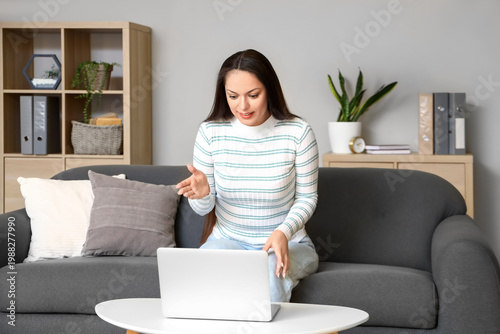 Young woman with laptop vid...