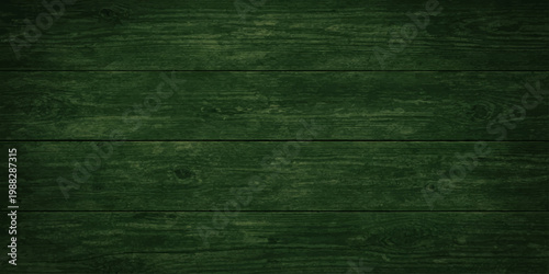 A dark green grunge wood texture featuring a vintage aged pattern on a rough wooden plank surface for a weathered material backdrop