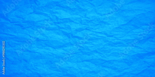 A clear liquid ripple reflects summer light on a wet aqua paper texture, creating an abstract blue background of transparent ocean waves and clean swimming pool water surfaces