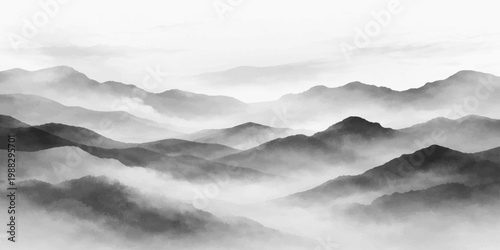 A misty blue mountain landscape at dawn with peaks rising through thick fog and clouds under the soft light of a golden sunrise