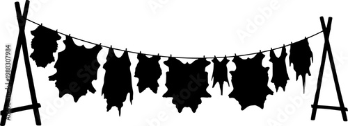 Silhouette of animal hides drying on a line between two wooden stands outdoor isolated on white background
