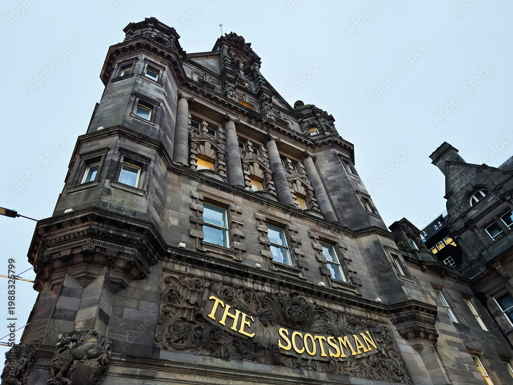 Fototapeta premium The Scotsman building facade in Edinburgh, Scotland, UK showcasing historic stone architecture, ornate carving and grand columns on a dramatic urban city street elevation