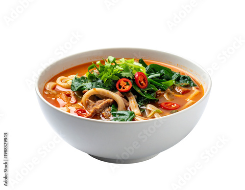 Spicy thai tom yum soup in white bowl with herbs and chili slices