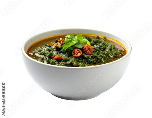Colorful spiced leafy soup in white bowl with garnish