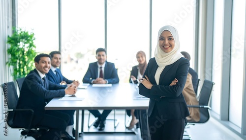 Group of diverse colleagues at a business meeting, a woman in hijab stands confidently. Sunlight streams through the window behind them