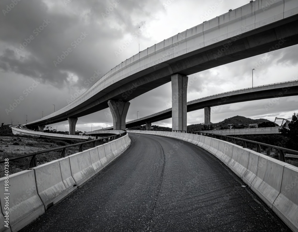 Naklejka premium Highway curves and overpasses create a complex road network under a cloudy sky in the early evening