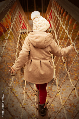 Vászonkép Child on the playground rope maze, entertainment, beautiful child