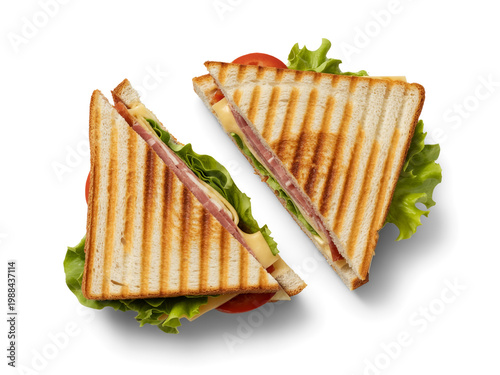A top-down view of a sliced club sandwich with fresh lettuce and tomato on a white plate