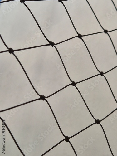 Close up of black safety netting for balcony against cloudy sky background