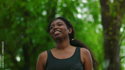 Tableau sur toile African American woman walking forward with carefree and happy smile while looki