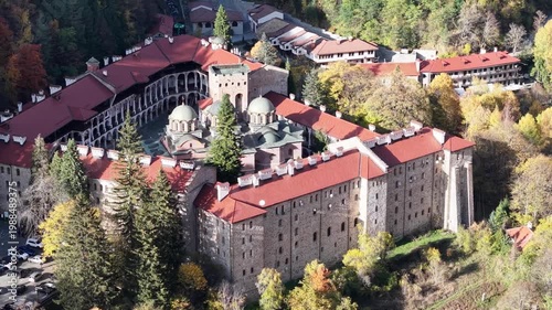 Close aerial shot of Rila Monastery showing the main monastery buildings and church domes.