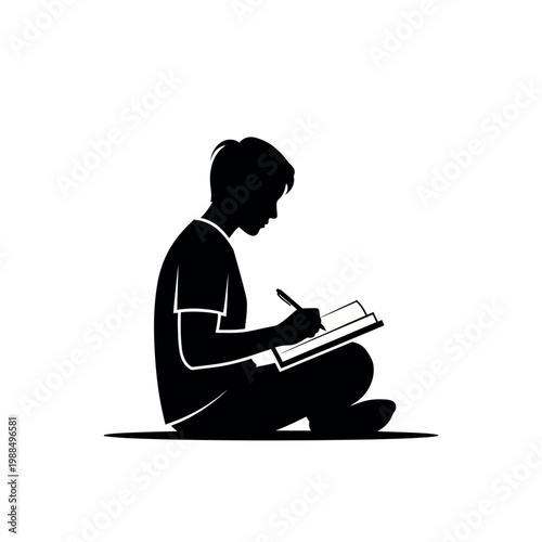 Boy sitting and writing on notebook.