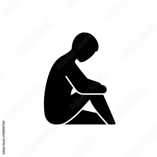 Silhouette of a person sitting alone and looking down.