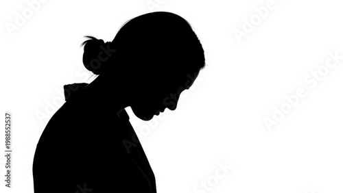 Silhouette profile portrait of a young woman looking down in contemplation