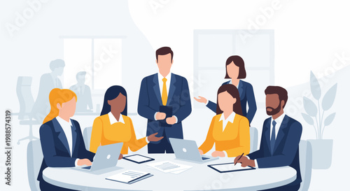 Diverse team collaborating around a table with laptops and papers