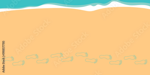 Footprints leading across a warm sandy beach towards the turquoise ocean waves