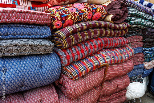 Piles of colorful mattresses and cushions for sale at a market in the streets of Old Delhi, India, Asia