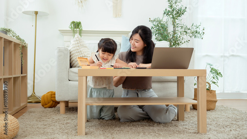 Mom Helps Kid With Homework at Home in the Living Room During Afternoon Study Time