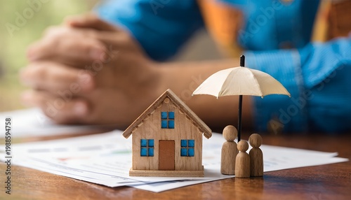 A wooden house model and a family of wooden figures under a small umbrella on top of financial documents, representing home insurance, family protection, and financial security