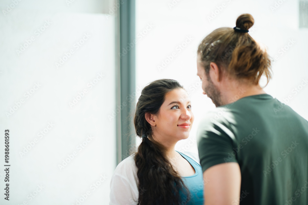 Fototapeta premium Father's Day Concept, woman and man face to face in bright room, eye contact with calm smile, close conversation