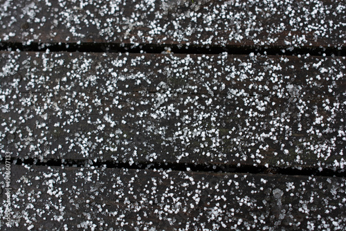 Winter snowfall and snowflakes on wooden background.