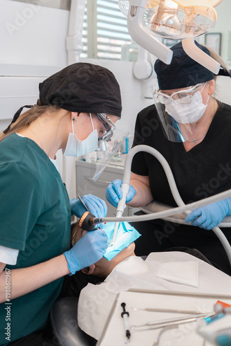 Obraz na płótnie Professional dentist using dental sandblaster for air abrasion tooth treatment and polish