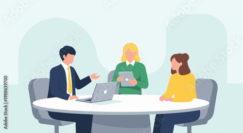 Three colleagues in a meeting discuss work around a table with a laptop and tablet