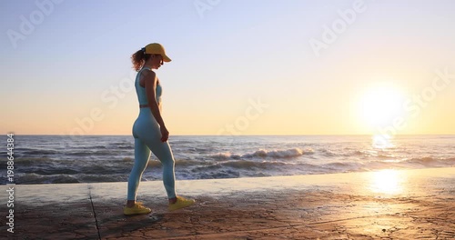 Fit woman showing muscles at the beach during summer vacation. Slow motion