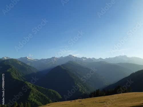 Canvas Print Scenic view of the high Caucasus mountains with lush green slopes and deep shadows during golden hour in the Svaneti region, Georgia