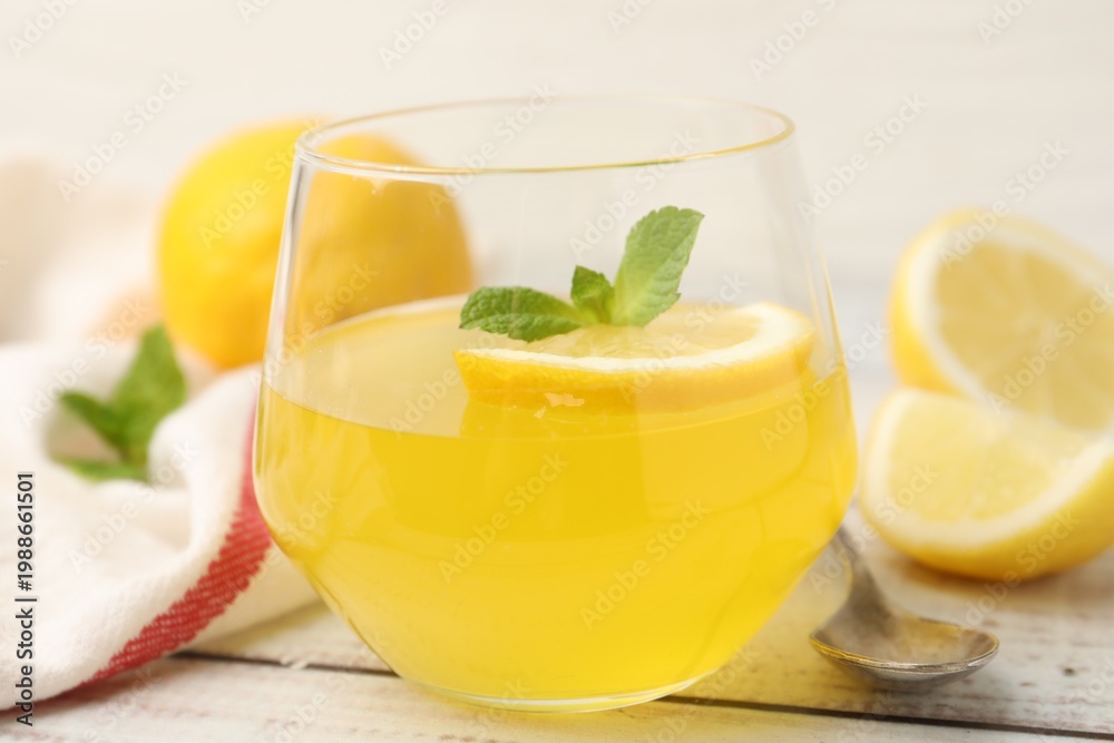 Fototapeta premium Tasty lemon jelly served with mint on white wooden table, closeup