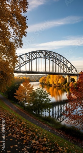 Arched bridge spans river with vibrant autumn trees reflected in water