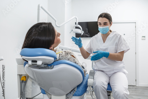 Fotografía Dentist explains dental procedure to patient in modern clinic during consultatio