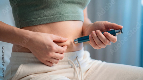 Young woman performing insulin injection or medication injection into her abdomen for diabetes or other treatment