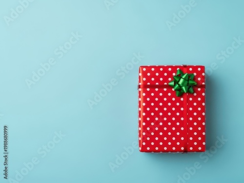 Beautifully wrapped red gift box with green ribbon on blue background