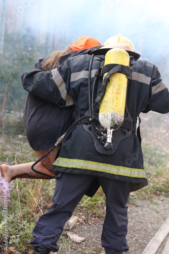 Firefighter with accident victim. Firefighter carrying victim from fire accident