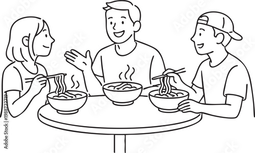 People eating noodles with chopsticks at a round table smiling